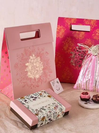 Our Festive Pink Gift Bag is a delightful Diwali treat, containing a box of 6 fudge brownies, a potli of honey choco almonds, and a box of 9 sugar-free mithai.