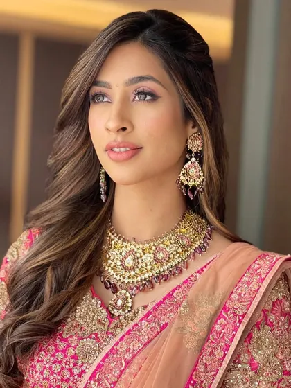 A beautiful portrait of the bride, her highlighted hair styled in soft waves, adding dimension and richness to the overall look.