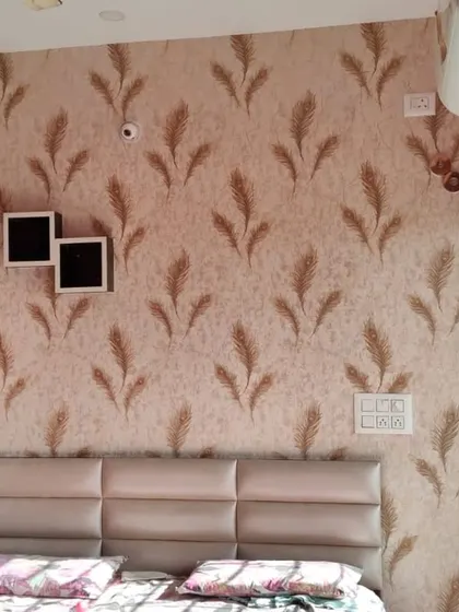 A feather-motif wallpaper in warm, earthy tones creates a soft and tranquil atmosphere in this bedroom. Installed as an accent wall behind the bed, it adds a layer of texture and sophistication.