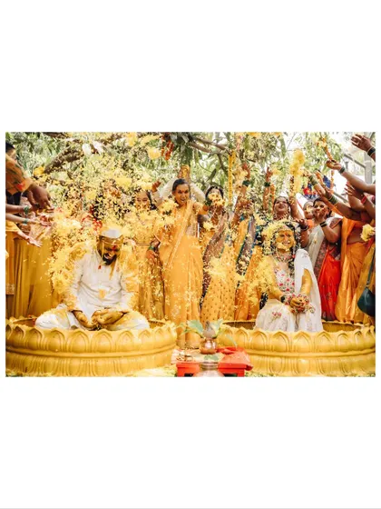 The vibrant energy of a Haldi ceremony. I capture the joy and chaos as family and friends shower the couple with flowers and blessings, a key part of many Indian wedding traditions.