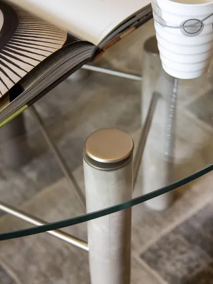 A detail of the Mystique Coffee Table, showing how the clear glass top is secured to the stylish legs. This design offers a perfect platform to showcase your favorite design objects or curated books.
