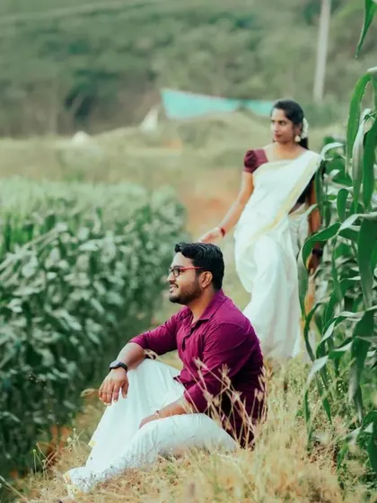 A serene moment in a lush cornfield, with the couple dressed in traditional Kerala attire. The simplicity of the white mundu and saree against the green landscape is timeless.