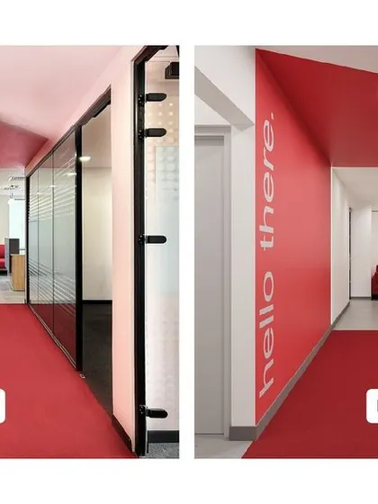 A render vs. reality comparison of a corridor leading from the reception. Our execution in red paint, flooring, and "hello there" graphic perfectly matches the 3D visualization, ensuring client satisfaction.