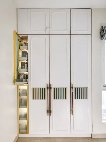 This custom wardrobe features a unique pull-out pantry for storing accessories. It's a clever, space-saving solution that is both functional and beautiful.