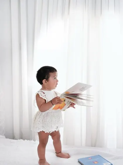 Reading little stories of life, one book at a time. This high-key, minimalist photo captures a child's curiosity in a beautiful and artistic way.