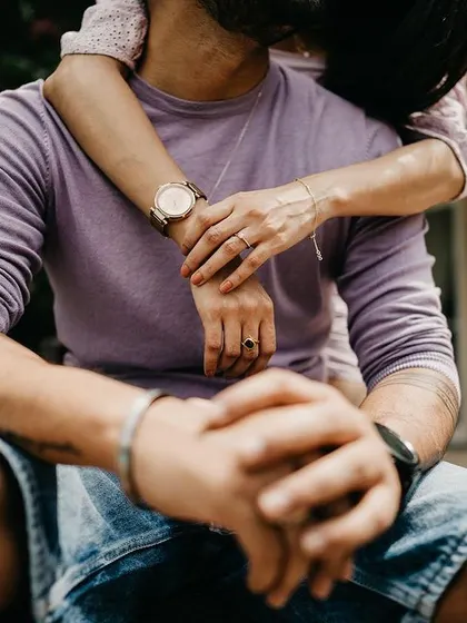 A close-up detail shot focusing on the couple's embrace and intertwined hands. Sometimes the smallest details tell the biggest story of love and connection.