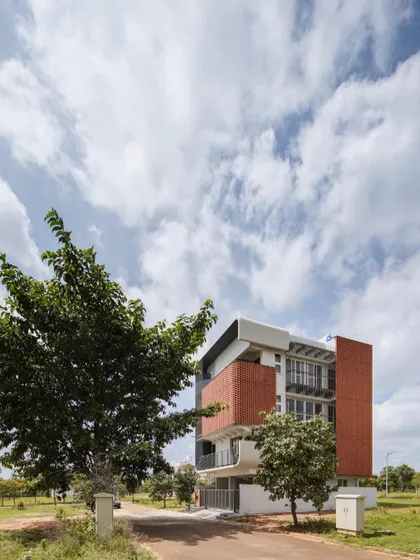'House Belaku' in its setting, showing how the design responds to the corner plot with a distinctive brick facade.