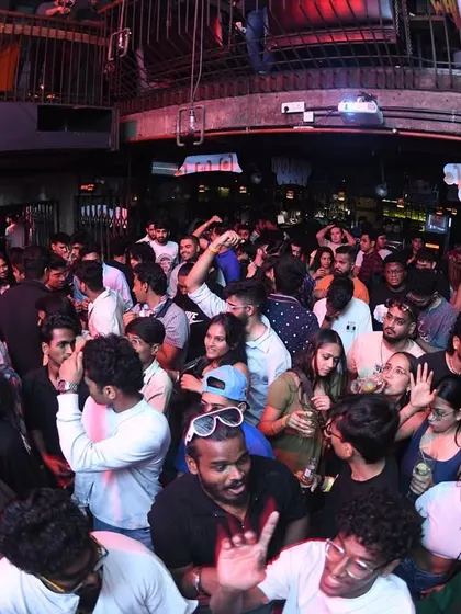 Another angle of the packed club, showing people dancing and socializing.