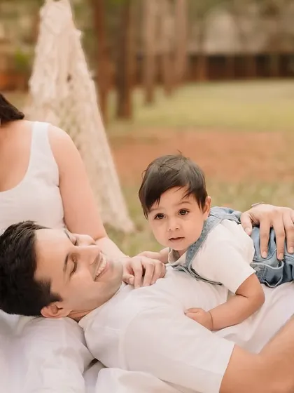 A relaxed moment with the family lounging on a blanket, the father lying down with his son on his chest.