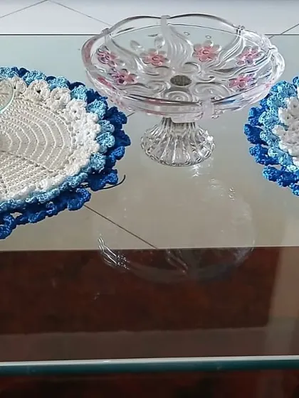 A set of two placemats with a beautiful blue floral border, shown here on a glass table. The design adds elegance without overwhelming the space.