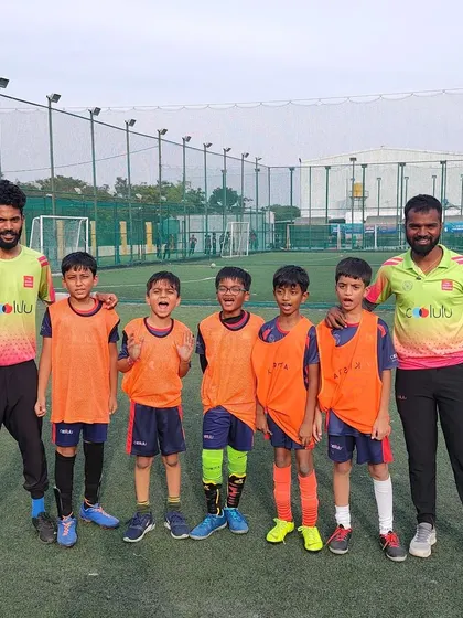 One of our U7 and U9 teams in their orange bibs, listening intently to their coach during an internal league game.