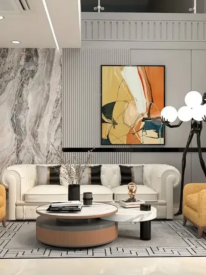 A luxurious living room with a mix of textures and colors. A classic white Chesterfield sofa is paired with bold yellow armchairs, set against a marble accent wall and a statement floor lamp.