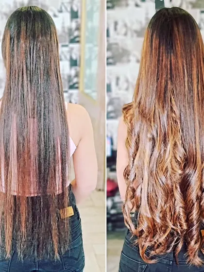 This client wanted a bold change. We gave her long, curly extensions with a rich, warm color and highlights for a truly head-turning look.