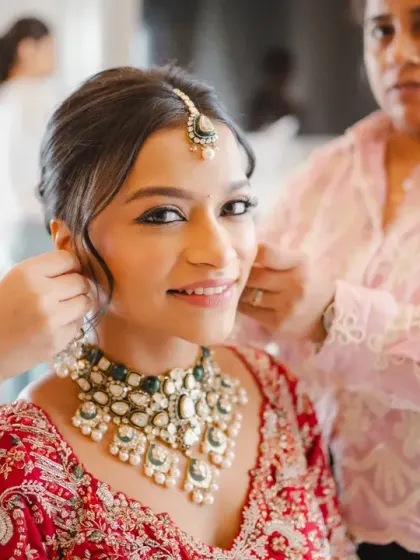 A beautiful close-up of the bride getting her earrings adjusted. Her gentle smile and the focus on the final touches highlight the excitement of the getting-ready process.