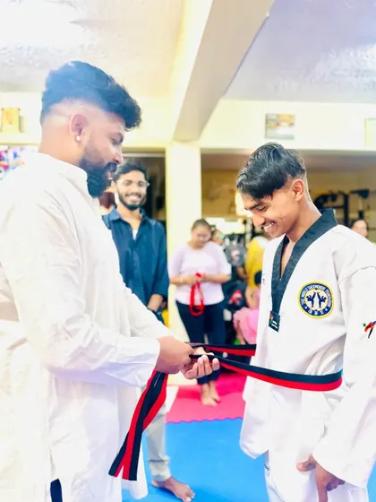A student receives his red and black belt.