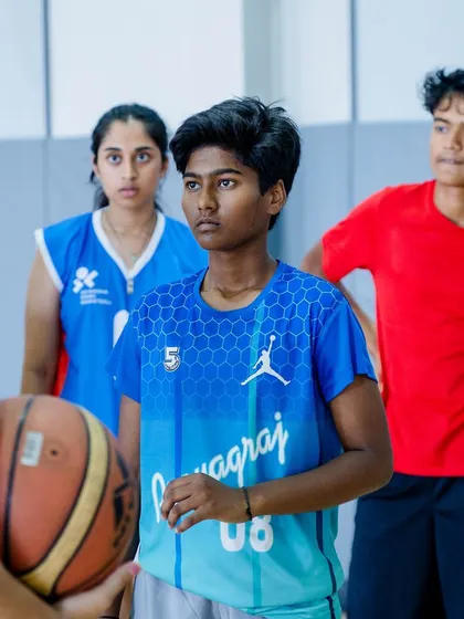 A group of focused young athletes listening to instructions.