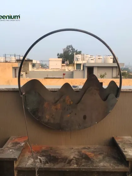 A custom-made metal art piece for a terrace feature wall, shown here before painting and finishing. This circular sculpture with a mountain motif will become a central element of the design.