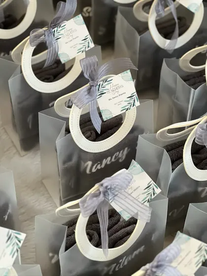 These personalized Teacher's Day gifts feature grey towels with embroidered names, beautifully packaged and ready for delivery.