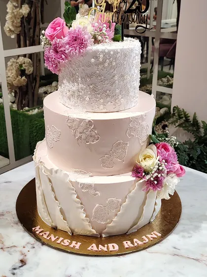The beauty of this three-tier cake is in its textures. I used a combination of sparkling sequins, delicate lace stenciling, and a draped fondant effect to create a piece that is both simple and incredibly elegant.
