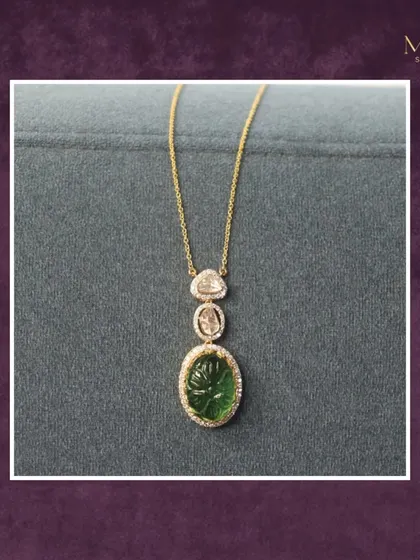 A touch of serene sophistication. This simple yet elegant pendant features a carved green gemstone and two Polki diamonds on a delicate gold chain. It's perfect for any occasion where subtle luxury is key.