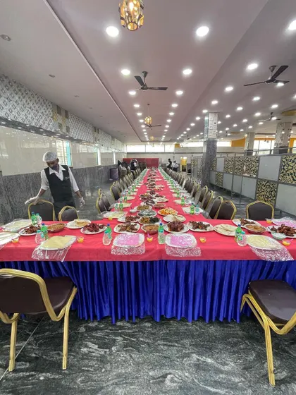 A long view of our Dastarkhwan arrangement at a wedding hall. The elegant table skirting and organized placement of dishes show our attention to detail for large-scale events.