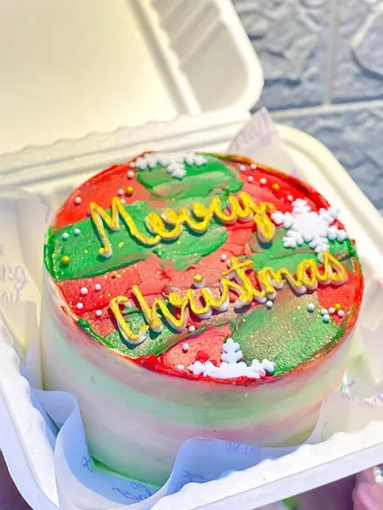 My "Merry Christmas" bento cake is the perfect little centerpiece for a holiday gathering. The festive red and green buttercream and delicate snowflake sprinkles make it a cheerful and delicious treat.