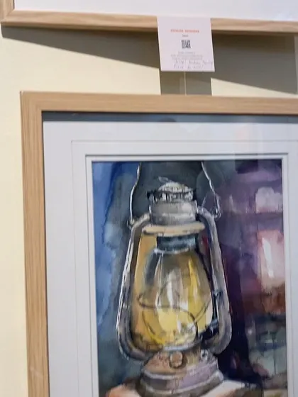 A detailed shot of my framed lantern painting at the gallery. The light wood frame complements the warm glow of the watercolor.