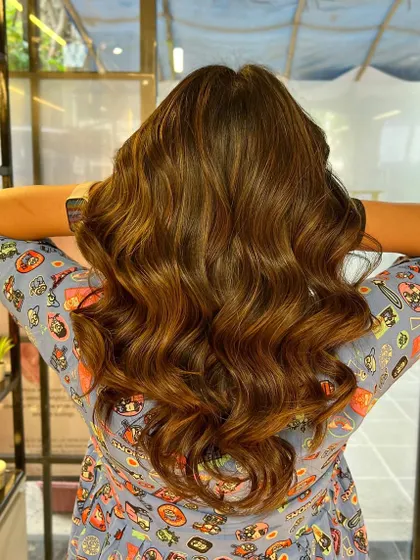 The back view of this caramel brown balayage shows the seamless blend and the healthy shine we achieved. The soft waves really make the color pop.