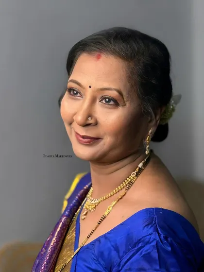 An elegant and graceful look for the bride's mother. The makeup is soft, and the hairstyle is a classic bun.
