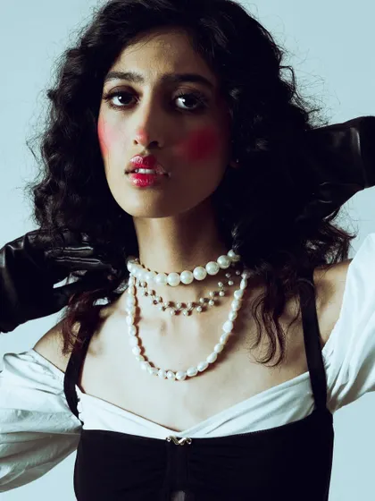 A close-up of the dramatic makeup, showing the bright red blush applied high on the cheeks and the glossy red lip.