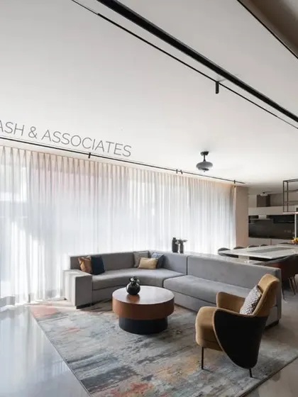 Clean, straight lines command the interiors of the family lounge, where warm wood tones are balanced by a bright, open kitchen area.