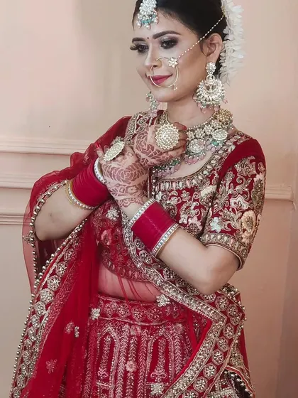 A happy bride showing off her custom jewellery. This set features large, ornate chandbalis and a matching choker, designed to stand out in photos.