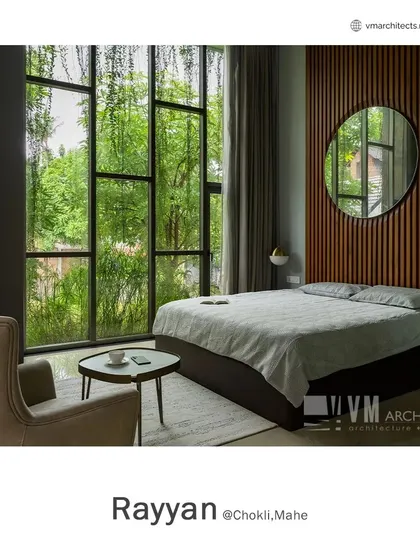 This serene bedroom at Rayyan features floor-to-ceiling windows with a view of the garden, a wooden slat accent wall, and a minimalist design for a calming atmosphere.