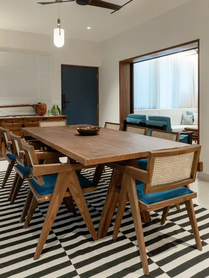 The dining room is the heart of the Keepsake home, featuring a large 8-seater table that encourages gathering. It is surrounded by open shelves displaying the client's artifacts, blending life, travel, and design into a single, cohesive narrative.