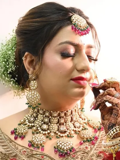 Our bride looking absolutely regal in the Pachi Kundan set. The combination of the choker, maang tikka, and nath perfectly complements her henna-adorned hands and bridal glow.