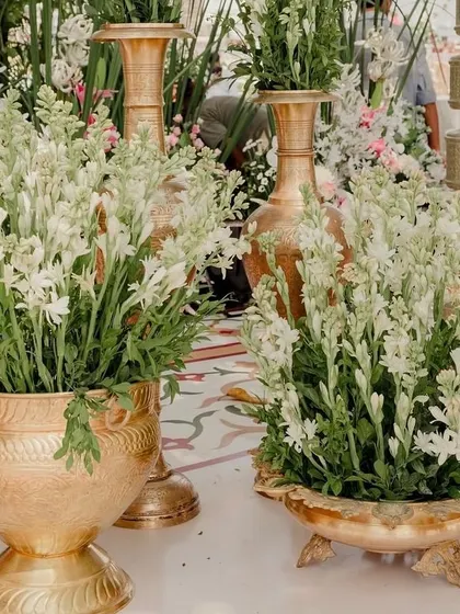 Details of a traditional yet contemporary wedding, with fresh tuberoses arranged in modern brass vases.