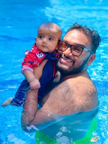 A proud dad holds his baby in the pool, showcasing the beautiful bond that forms in our classes.