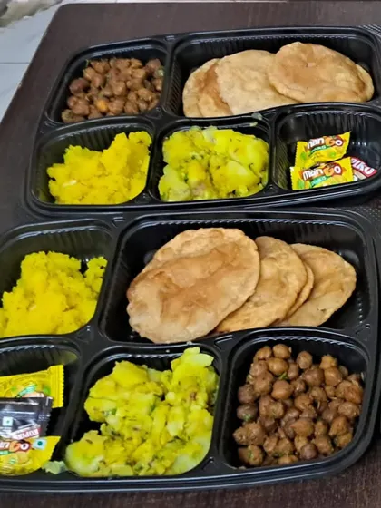 Celebrating a festival at home? Our packed thalis are the perfect solution. This Ganesh Chaturthi special meal includes puri, sukha kala chana, aloo sabzi, and halwa, all prepared without onion or garlic.