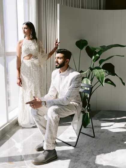 A stylish, editorial-style portrait of the couple by a window, bathed in natural light. A modern and sophisticated shot.