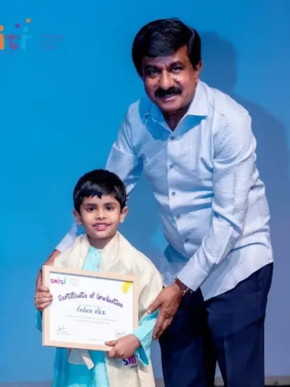A boy in his graduation attire accepts his certificate with a proud smile. We celebrate each child's growth and readiness for the next step in their education.