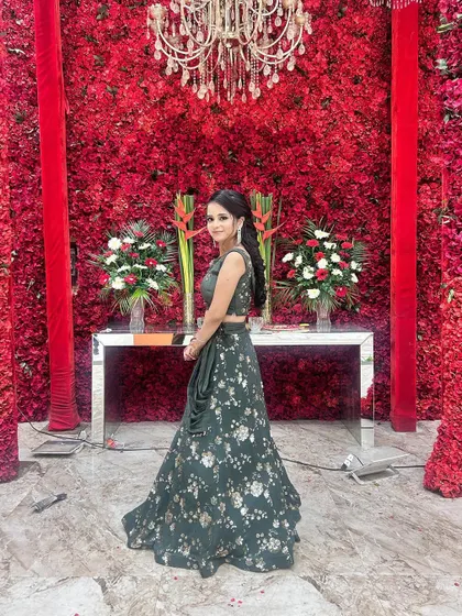 A side view of our client in the green floral lehenga, showing how beautifully the skirt flows. Perfect for a wedding reception.