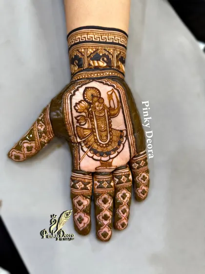 When a Karwa Chauth client is a devotee of Shreenath Ji, the design becomes a prayer. This portrait of the deity, framed by traditional patterns, turns the hand into a canvas of devotion.