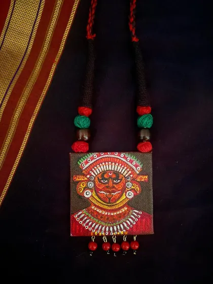 A duplicate image of the Theyyam pendant.