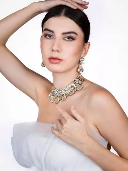 An ethereal and delicate portrait. The soft, high-key lighting and the simple white tulle create a pure and angelic look, with all the focus on the model's serene expression and the beautiful jewelry.