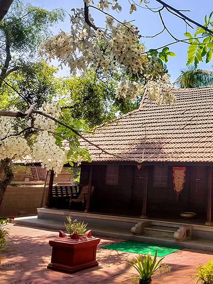 A traditional Kerala-style house on campus, surrounded by blooming trees. The architecture here is a blend of traditional aesthetics and natural integration.