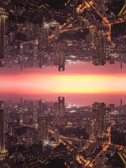 A creative edit of Mumbai's nightscape, mirrored to create a surreal, matrix-like world with a sunset horizon in the middle.