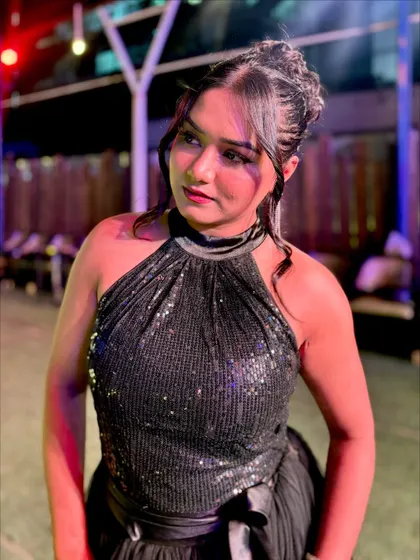 A close-up in the black halter-neck gown. The sequined top adds a touch of glamour to the classic black dress.