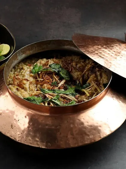 A traditional copper pot of Haleem, a rich and hearty dish essential to any Iftaar menu.