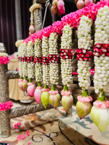 A detailed shot of the exquisite floral decorations on a naming ceremony cradle. I use fresh jasmine, pink roses, and lotus buds to create these beautiful, fragrant garlands.