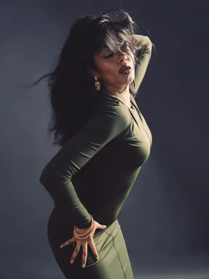 A high-energy pose with dramatic hair movement, creating a sense of wild elegance.